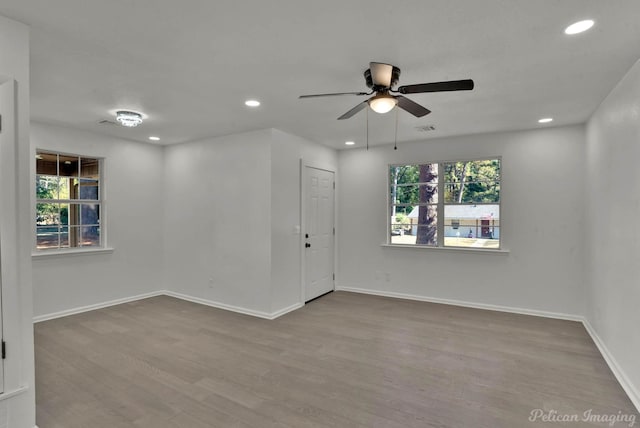 unfurnished room with light hardwood / wood-style flooring, plenty of natural light, and ceiling fan