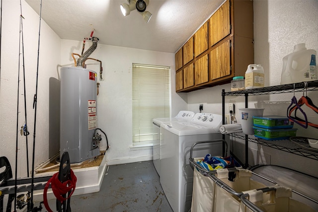 washroom with cabinets, gas water heater, and washer and clothes dryer