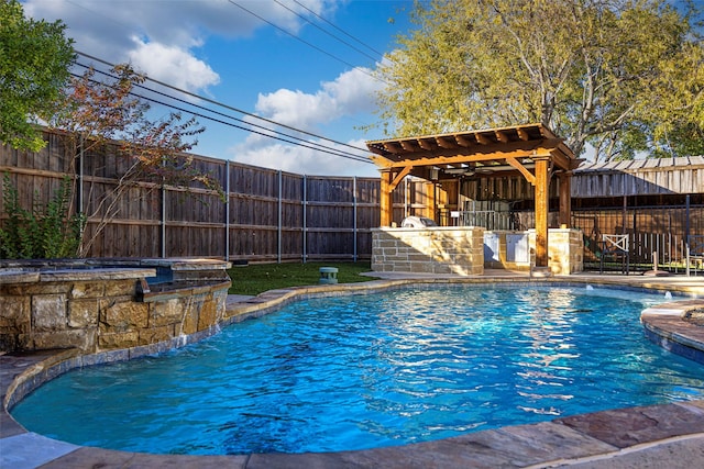 view of swimming pool with an in ground hot tub, a bar, and pool water feature