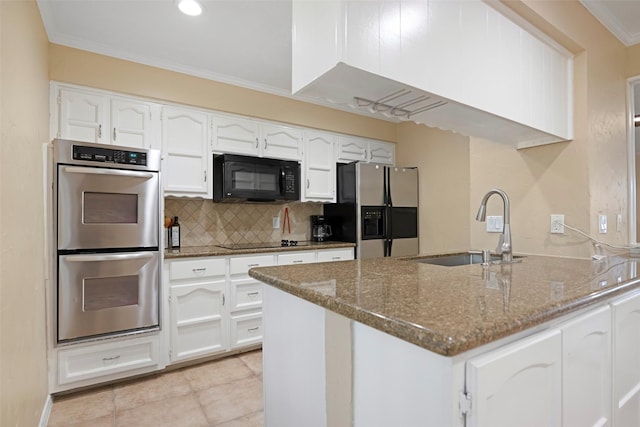 kitchen with dark stone countertops, white cabinetry, sink, and black appliances