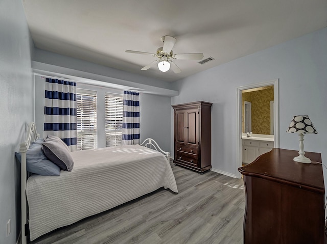 bedroom featuring ceiling fan, light wood-type flooring, and ensuite bathroom