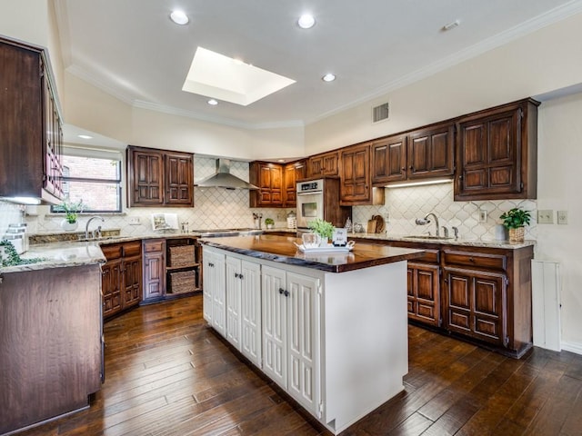 kitchen featuring a center island, a skylight, oven, and dark hardwood / wood-style floors