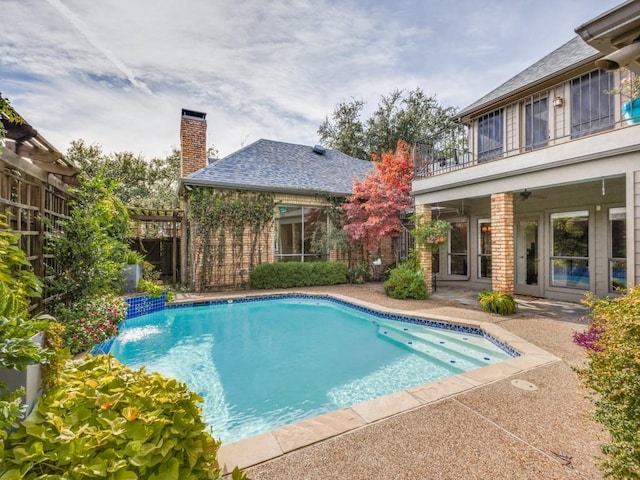 view of swimming pool featuring pool water feature and ceiling fan