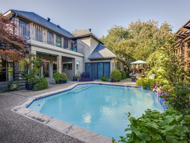 view of swimming pool with ceiling fan and a patio area