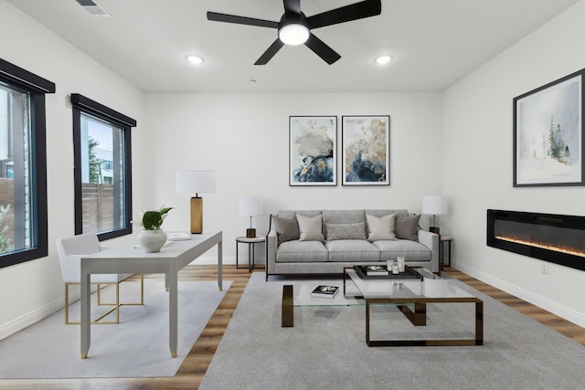 living room with wood-type flooring and ceiling fan