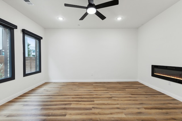 unfurnished room with ceiling fan and hardwood / wood-style flooring