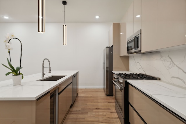 kitchen with stainless steel appliances, light stone counters, sink, decorative light fixtures, and tasteful backsplash