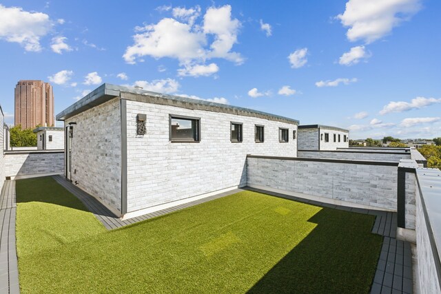 view of side of property with a balcony and a yard