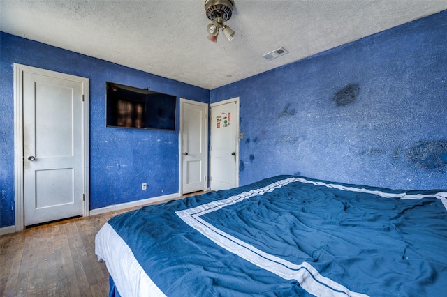 bedroom with hardwood / wood-style floors and a textured ceiling