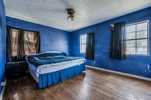 bedroom with dark hardwood / wood-style flooring and a textured ceiling