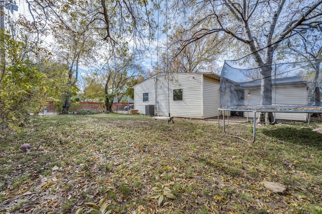 view of home's exterior with a trampoline, cooling unit, and a yard