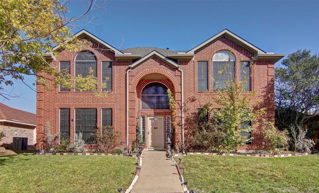 view of front property featuring a front lawn and central air condition unit