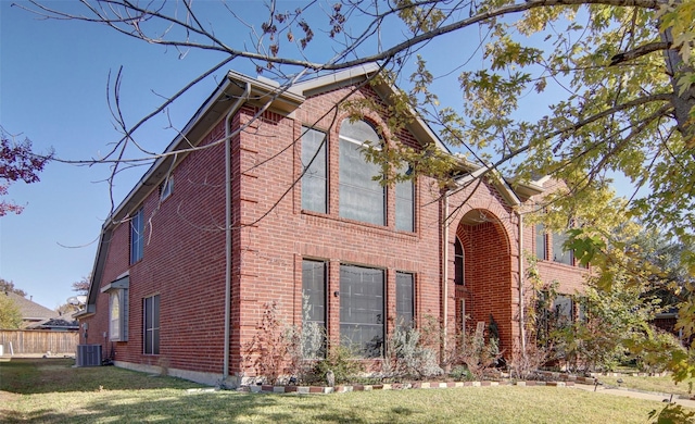 view of front facade with central air condition unit and a front lawn