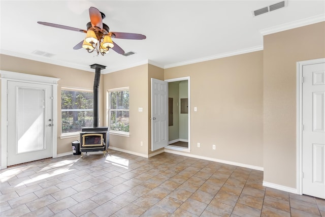 unfurnished living room with a wood stove, crown molding, and ceiling fan