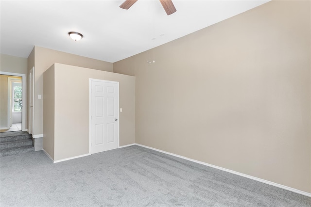 empty room featuring ceiling fan and carpet