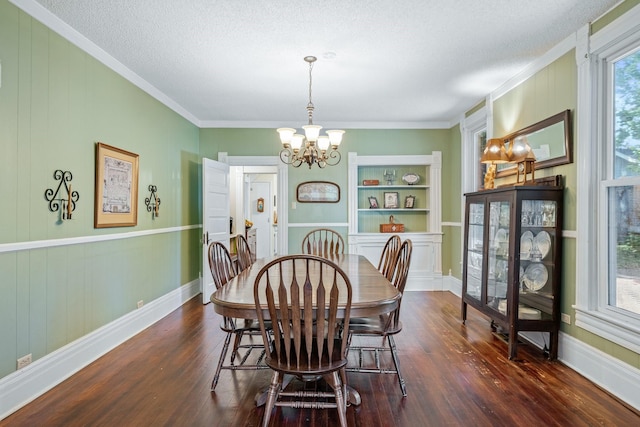 dining room with crown molding, built in features, a textured ceiling, dark hardwood / wood-style flooring, and a chandelier