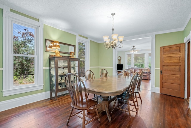 dining area featuring a textured ceiling, ceiling fan with notable chandelier, crown molding, and dark wood-type flooring