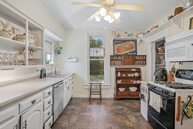 kitchen with white appliances, white cabinetry, a healthy amount of sunlight, and sink