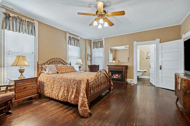 bedroom featuring ensuite bath, ceiling fan, dark wood-type flooring, a textured ceiling, and ornamental molding