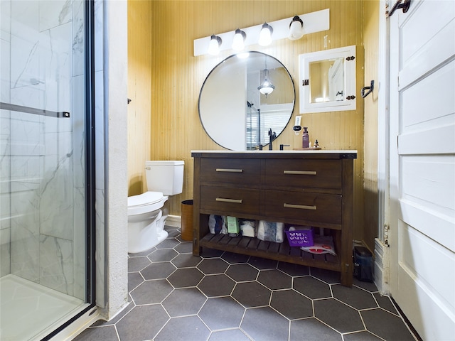 bathroom featuring tile patterned flooring, vanity, toilet, and a shower with shower door