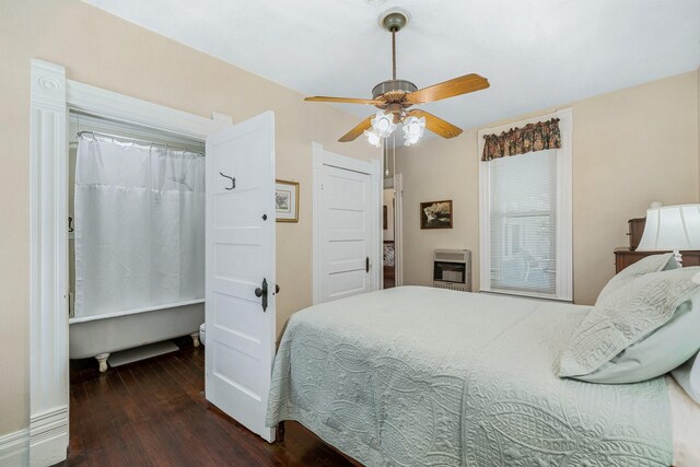 bedroom featuring ceiling fan, dark wood-type flooring, and heating unit