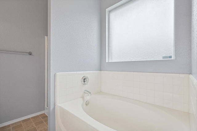 bathroom with a tub to relax in and plenty of natural light