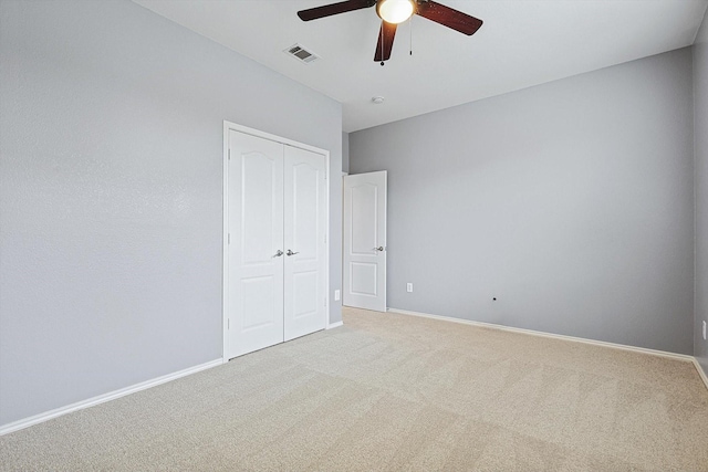 unfurnished bedroom with carpet flooring, ceiling fan, and a closet