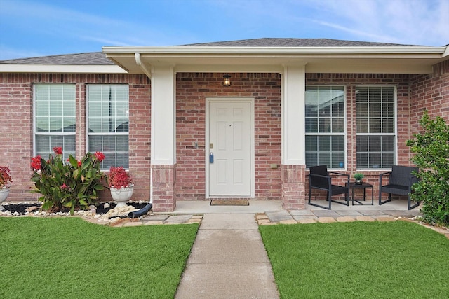 property entrance featuring a lawn