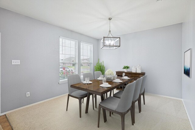 dining room featuring a chandelier and light colored carpet