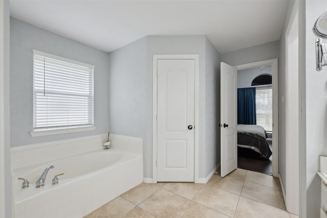 bathroom with tile patterned floors and tiled tub