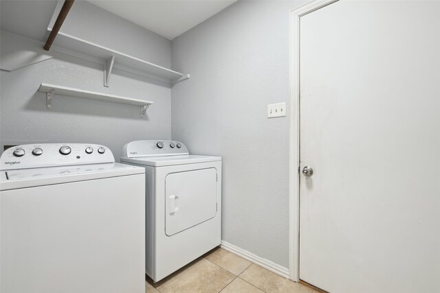 laundry area with washer and dryer and light tile patterned floors