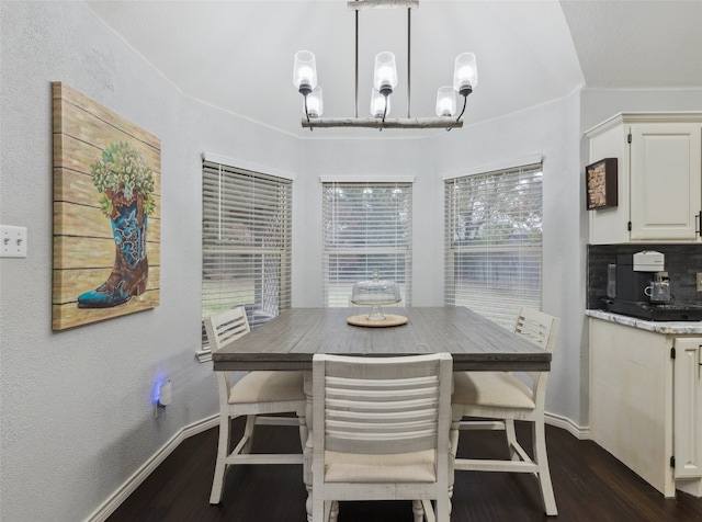 dining space featuring plenty of natural light, dark hardwood / wood-style floors, and an inviting chandelier