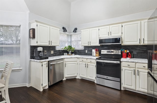 kitchen featuring decorative backsplash, dark wood-type flooring, white cabinets, and stainless steel appliances