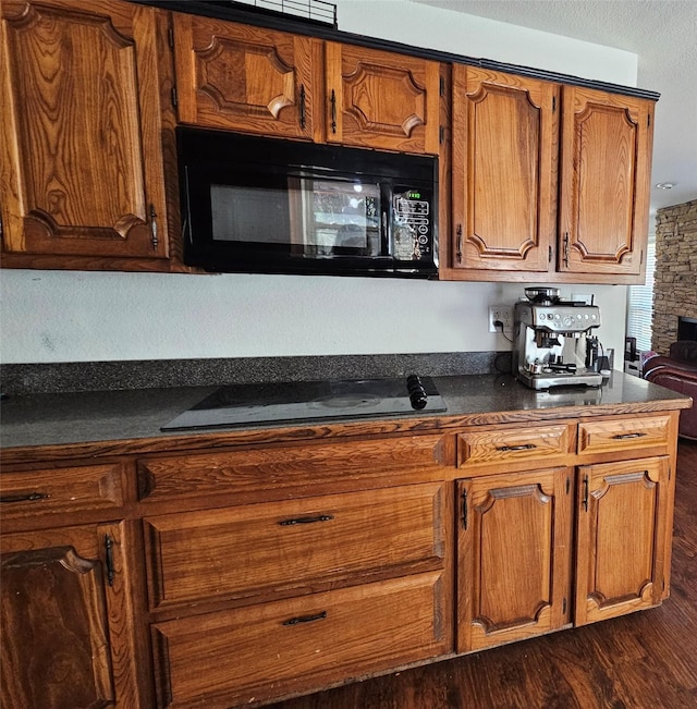 kitchen featuring dark hardwood / wood-style floors and black appliances