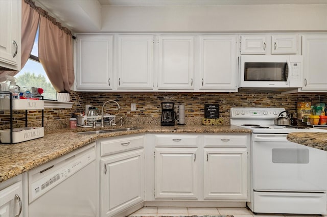 kitchen with sink, white cabinets, white appliances, light stone countertops, and backsplash