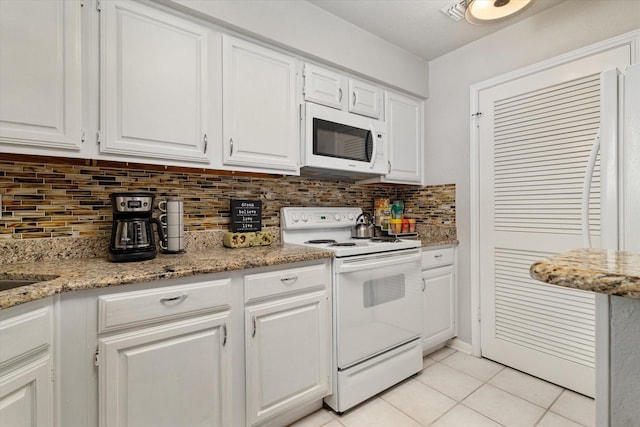 kitchen featuring tasteful backsplash, light tile patterned floors, white appliances, and white cabinets