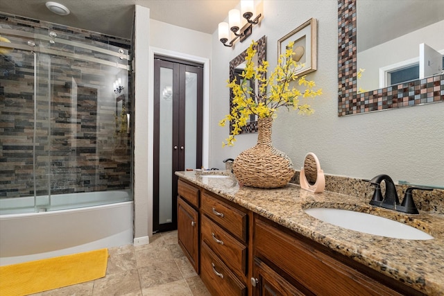 bathroom featuring bath / shower combo with glass door and vanity