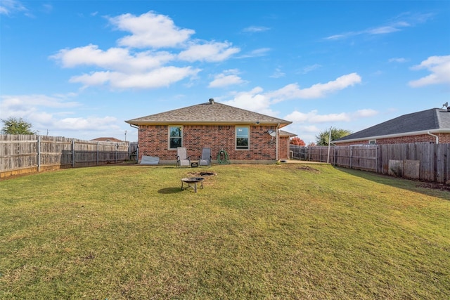 back of property featuring an outdoor fire pit and a yard