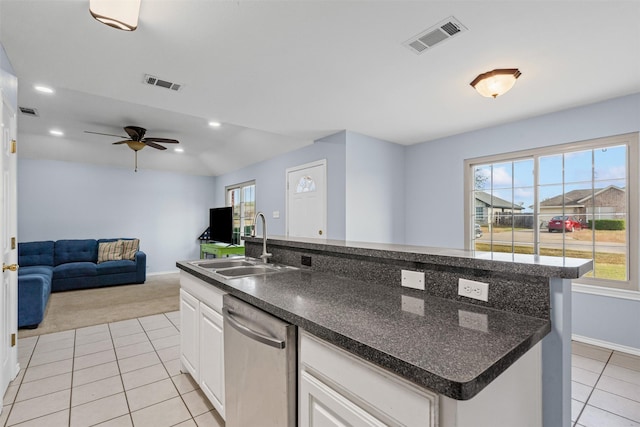 kitchen featuring sink, white cabinetry, light tile patterned floors, dishwasher, and an island with sink