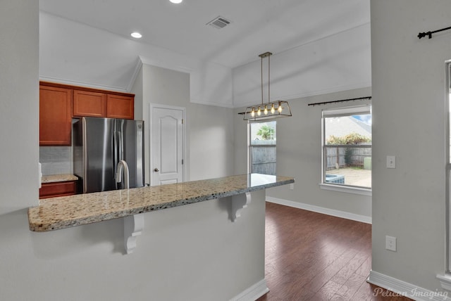 kitchen with pendant lighting, lofted ceiling, black dishwasher, sink, and dark wood-type flooring