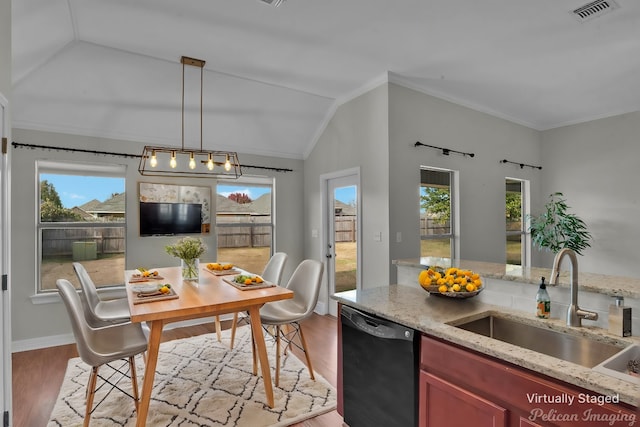 kitchen featuring sink, light stone counters, crown molding, kitchen peninsula, and black appliances