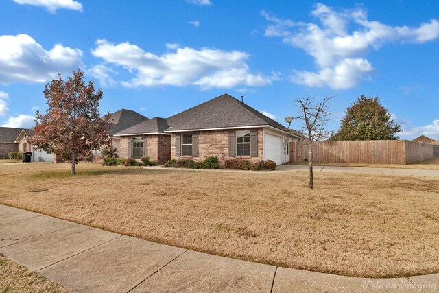 ranch-style house with a garage and a front lawn