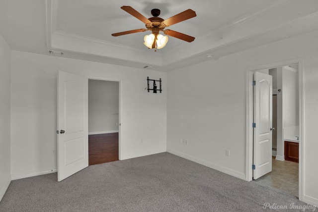 carpeted spare room featuring ceiling fan, ornamental molding, and a raised ceiling