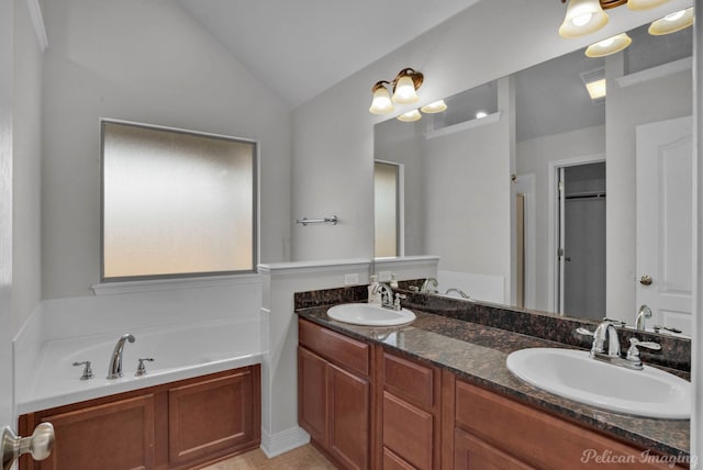 bathroom featuring vanity, a tub to relax in, vaulted ceiling, and tile patterned floors