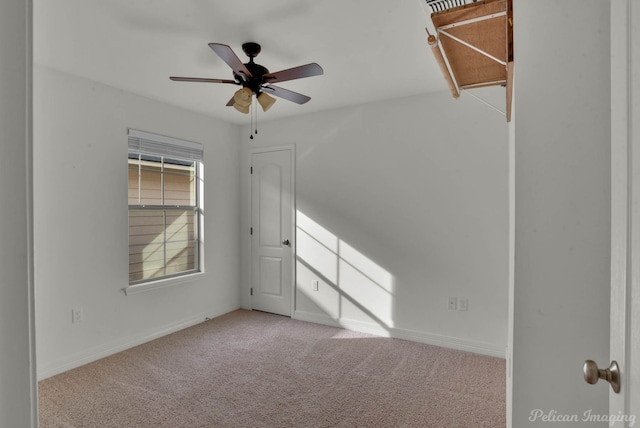 carpeted spare room with ceiling fan