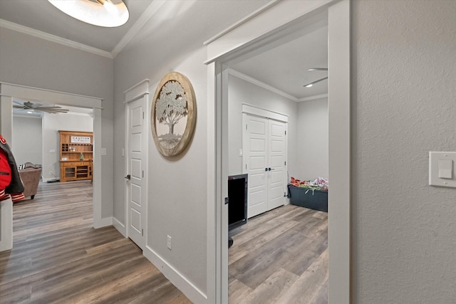 hallway with hardwood / wood-style floors and crown molding