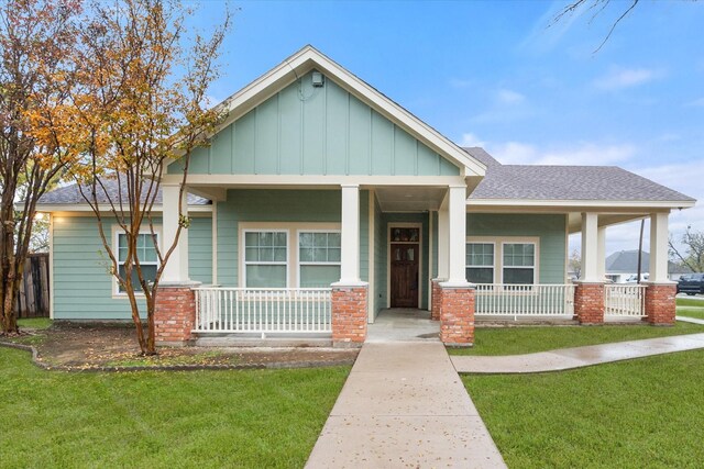 craftsman-style home featuring a front lawn, covered porch, and a garage