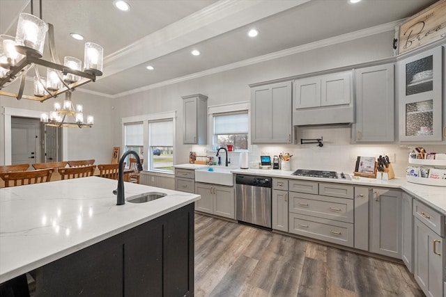 kitchen with dark hardwood / wood-style floors, stainless steel appliances, decorative light fixtures, and sink