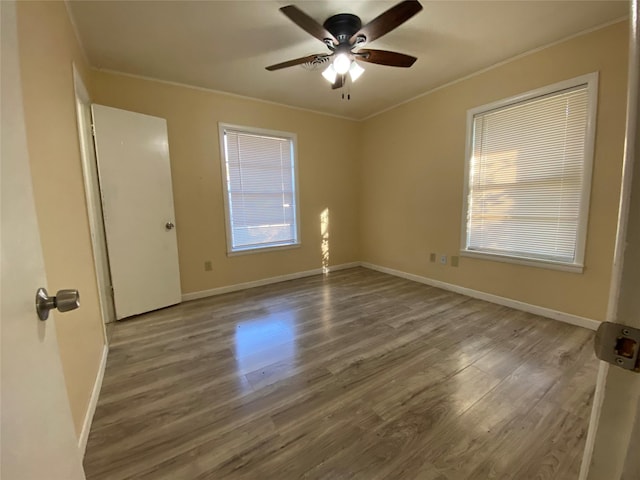 spare room featuring wood-type flooring, ceiling fan, and crown molding