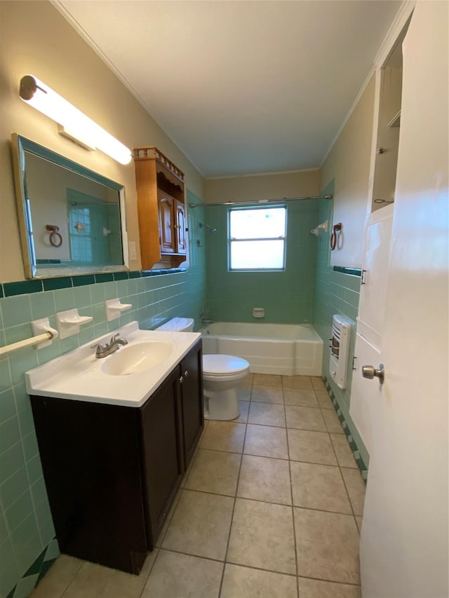 full bathroom featuring tiled shower / bath combo, tile patterned flooring, heating unit, vanity, and tile walls